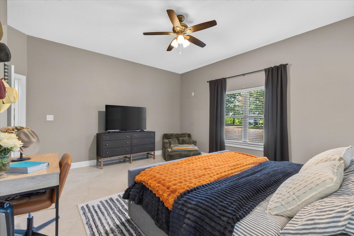 145 Cardinal Loop Paige, TX 78659 - Photo 21 of 40 A tranquil primary suite features a ceiling fan, window with blinds, and a practical workspace.