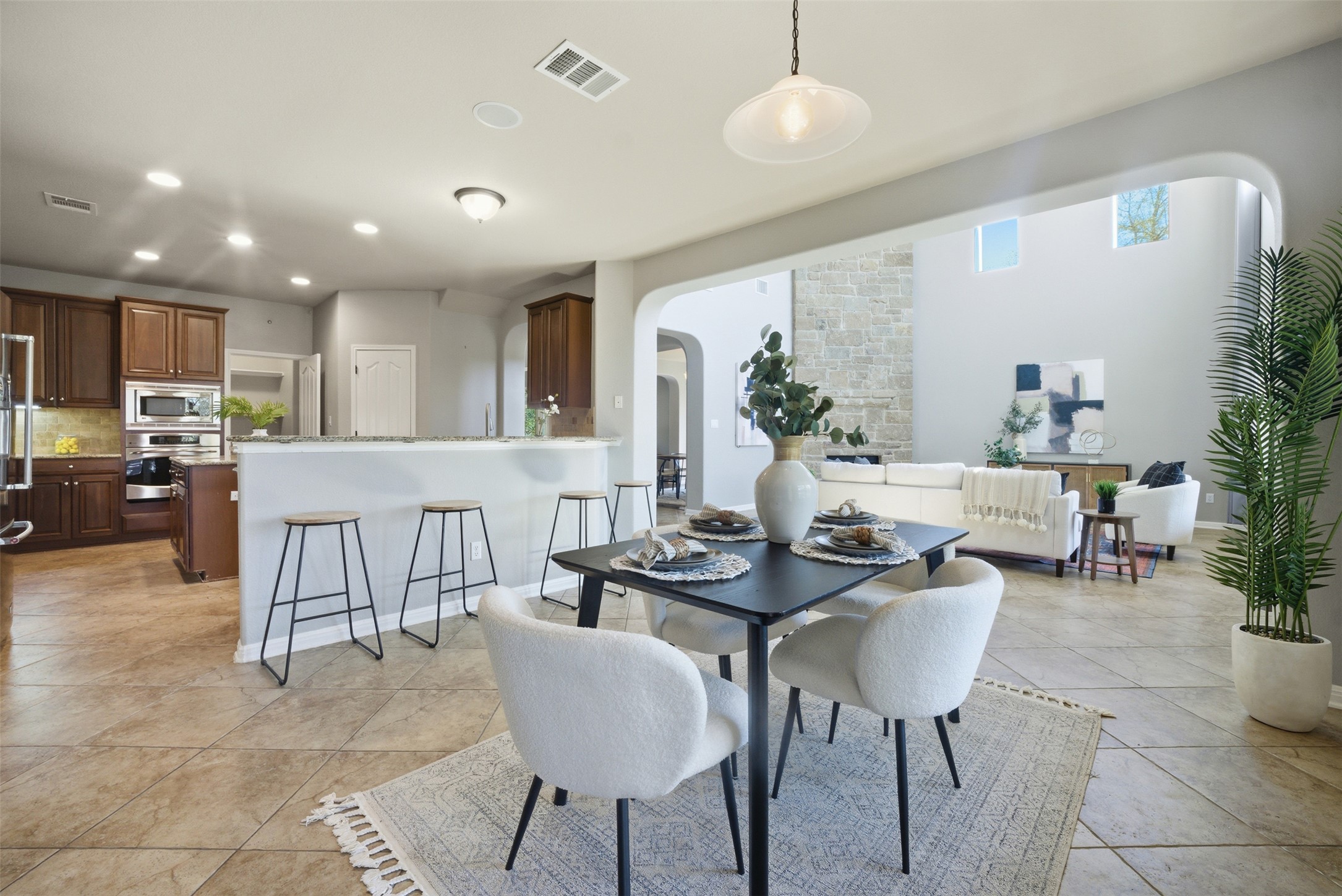 16100 Spillman Ranch Loop Austin, TX 78738 - Photo 16 of 39 a kitchen with a dining table chairs and white cabinets
