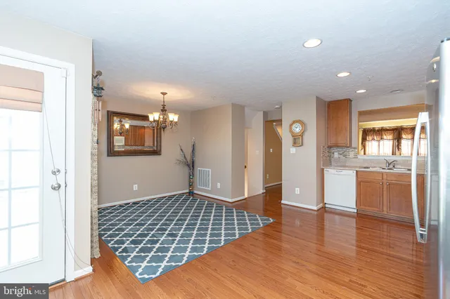 a view of a livingroom with kitchen and wooden floor