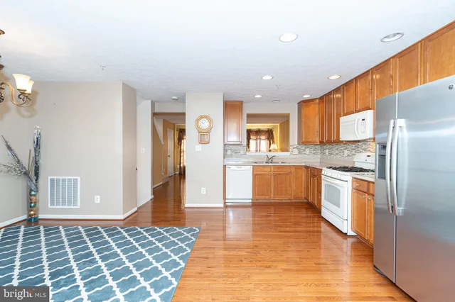 a kitchen with stainless steel appliances granite countertop a refrigerator and a stove top oven