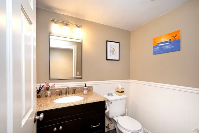 a bathroom with a toilet a sink and mirror