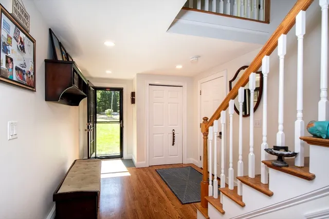 a view of front door and entryway with wooden floor