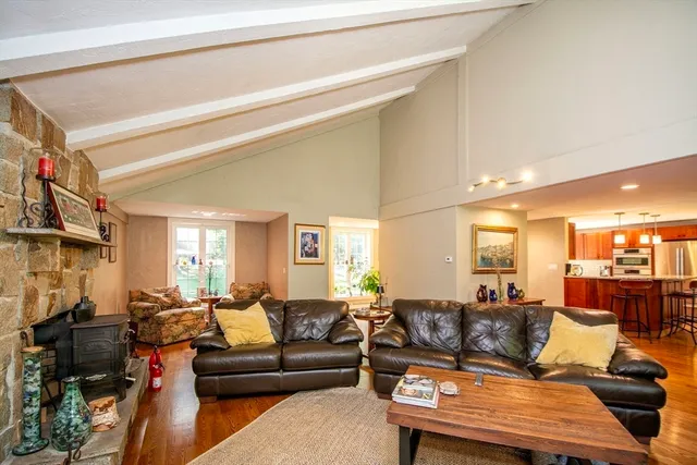 a living room with furniture kitchen view and a large window