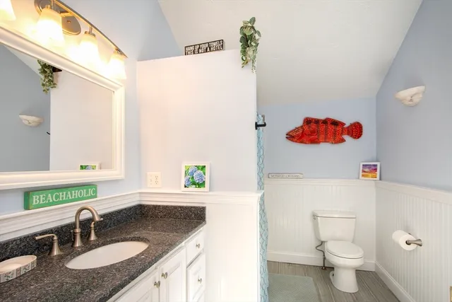 a bathroom with a granite countertop sink a toilet and a mirror