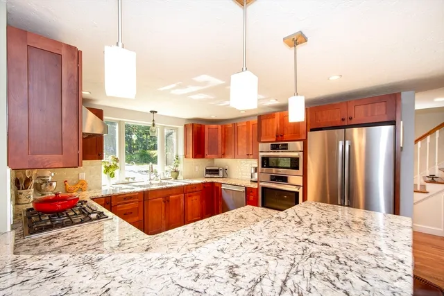 a kitchen with stainless steel appliances kitchen island granite countertop a sink window and refrigerator