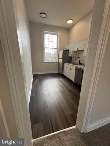 a kitchen with cabinets and wooden floor