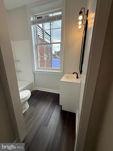 a bathroom with a toilet a sink and a window