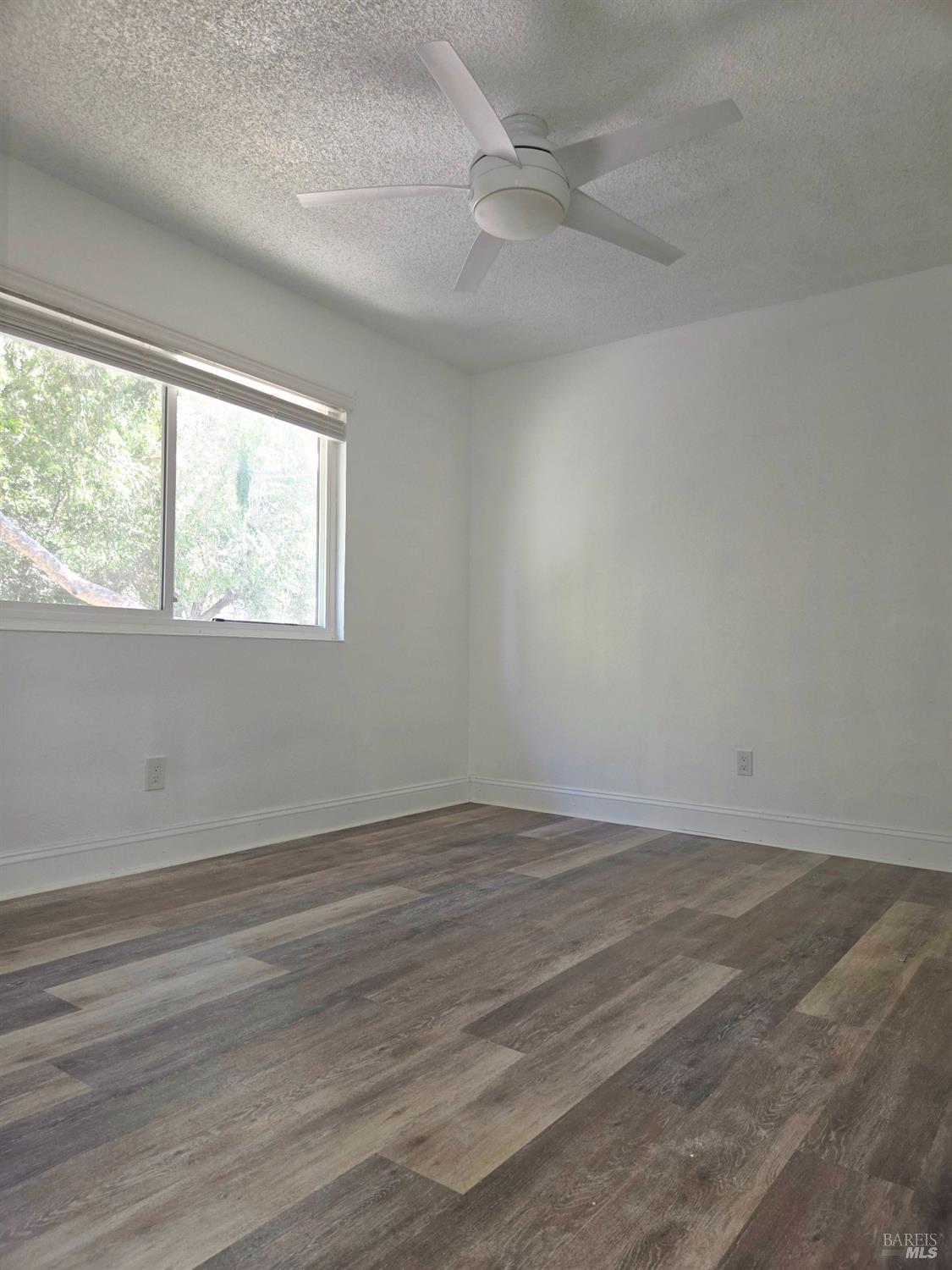 140 Del Rio Court, Unit 4 Vacaville, CA 95687 - Photo 14 of 25 an empty room with wooden floor and windows