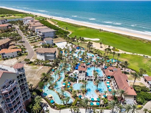 a view of a dining room and livingroom with furniture wooden floor a chandelier