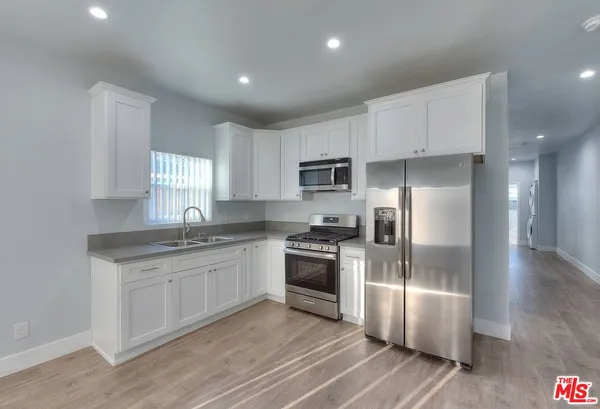 a kitchen with a refrigerator sink and cabinets