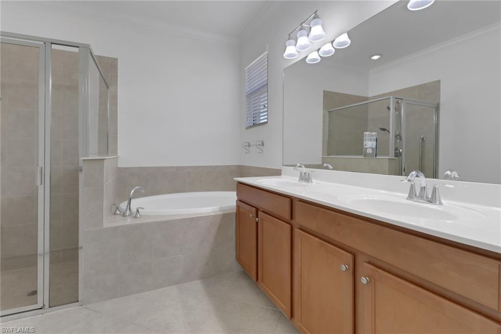 13527 San Georgio Drive Estero, FL 33928 - Photo 12 of 49 a bathroom with a tub a double vanity sink and a mirror