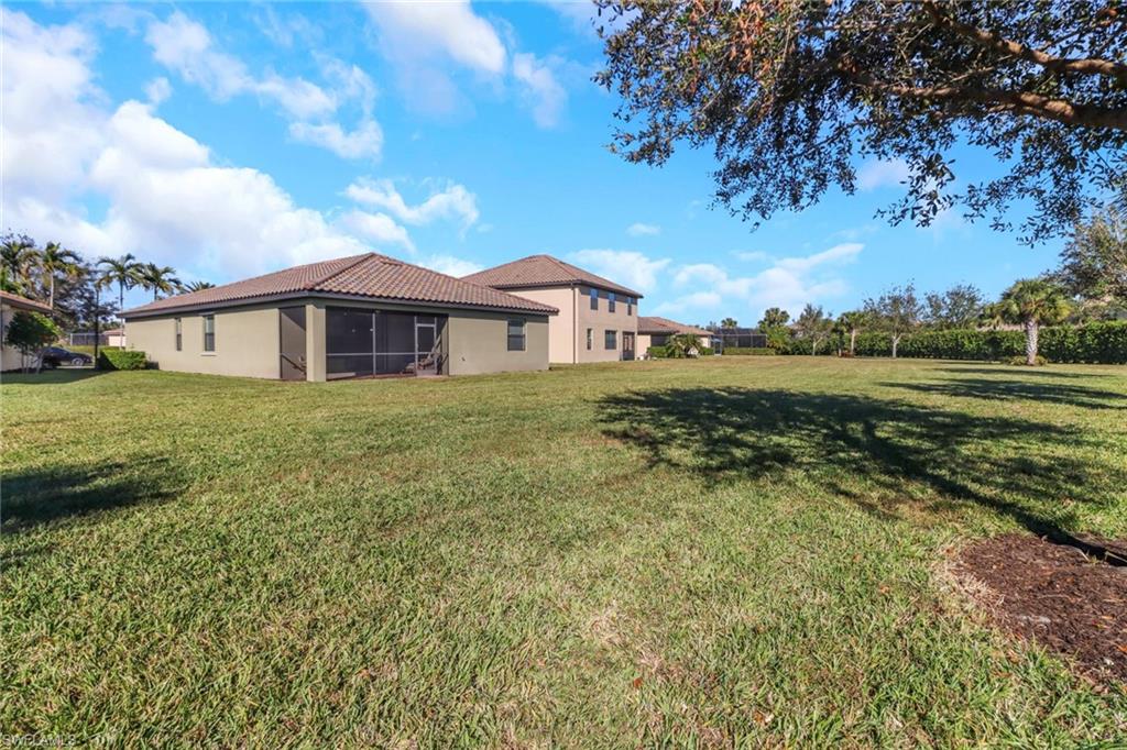 13527 San Georgio Drive Estero, FL 33928 - Photo 24 of 49 a view of a house with a big yard and large trees