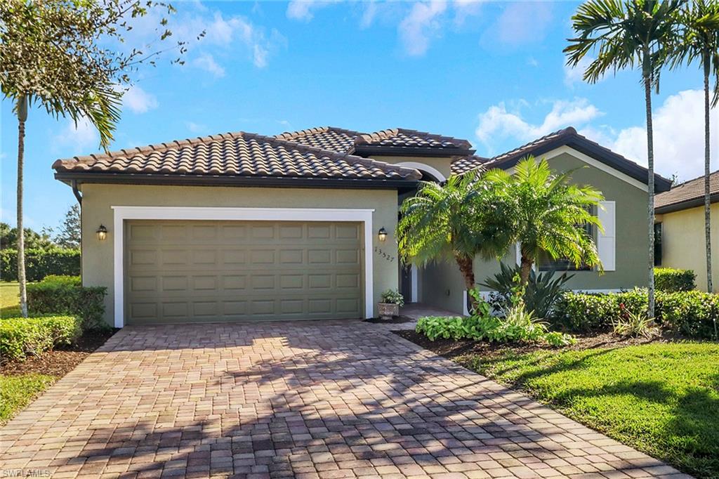 13527 San Georgio Drive Estero, FL 33928 - Photo 25 of 49 a front view of a house with a yard and garage