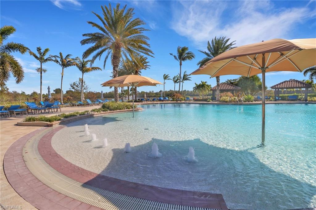 13527 San Georgio Drive Estero, FL 33928 - Photo 38 of 49 a view of a lake with a table and chairs under an umbrella