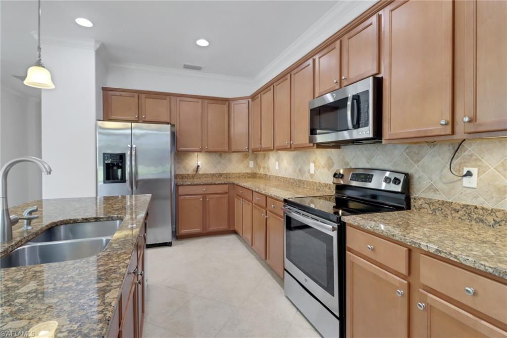 13527 San Georgio Drive Estero, FL 33928 - Photo 4 of 49 a kitchen with stainless steel appliances granite countertop a sink dishwasher a stove and a microwave oven with cabinets