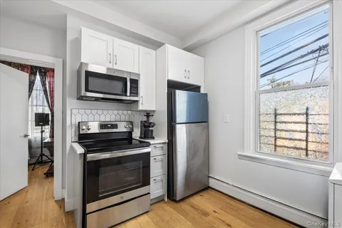 a kitchen with wooden cabinets a stainless steel appliances and wooden floor