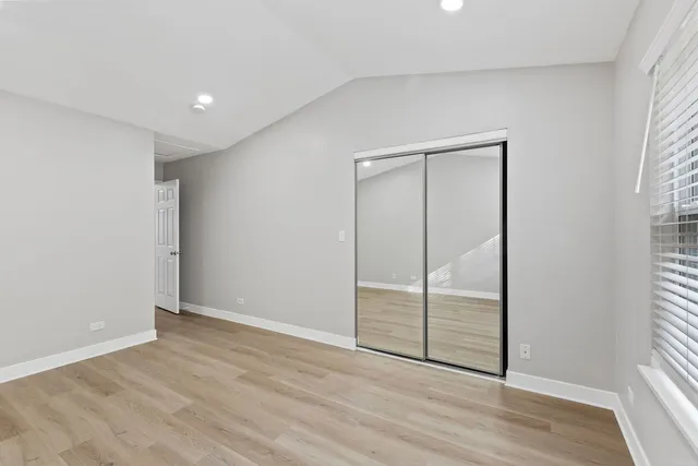 an empty room with wooden floor and sliding door