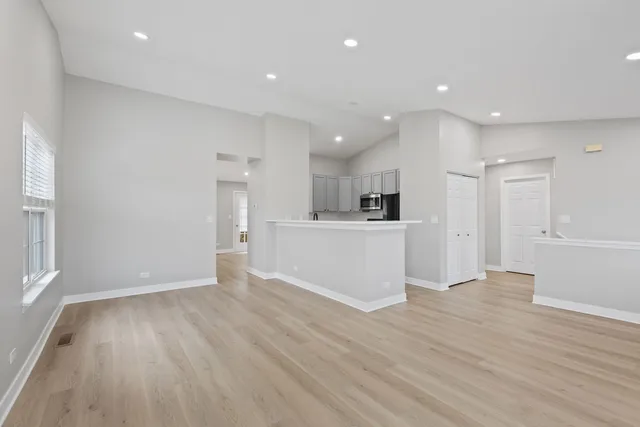 a view of a kitchen with wooden floor and windows