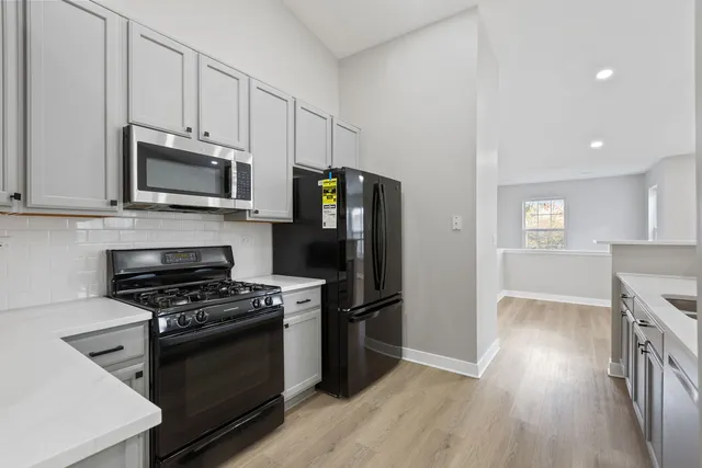 a kitchen with granite countertop a stove a microwave and a refrigerator