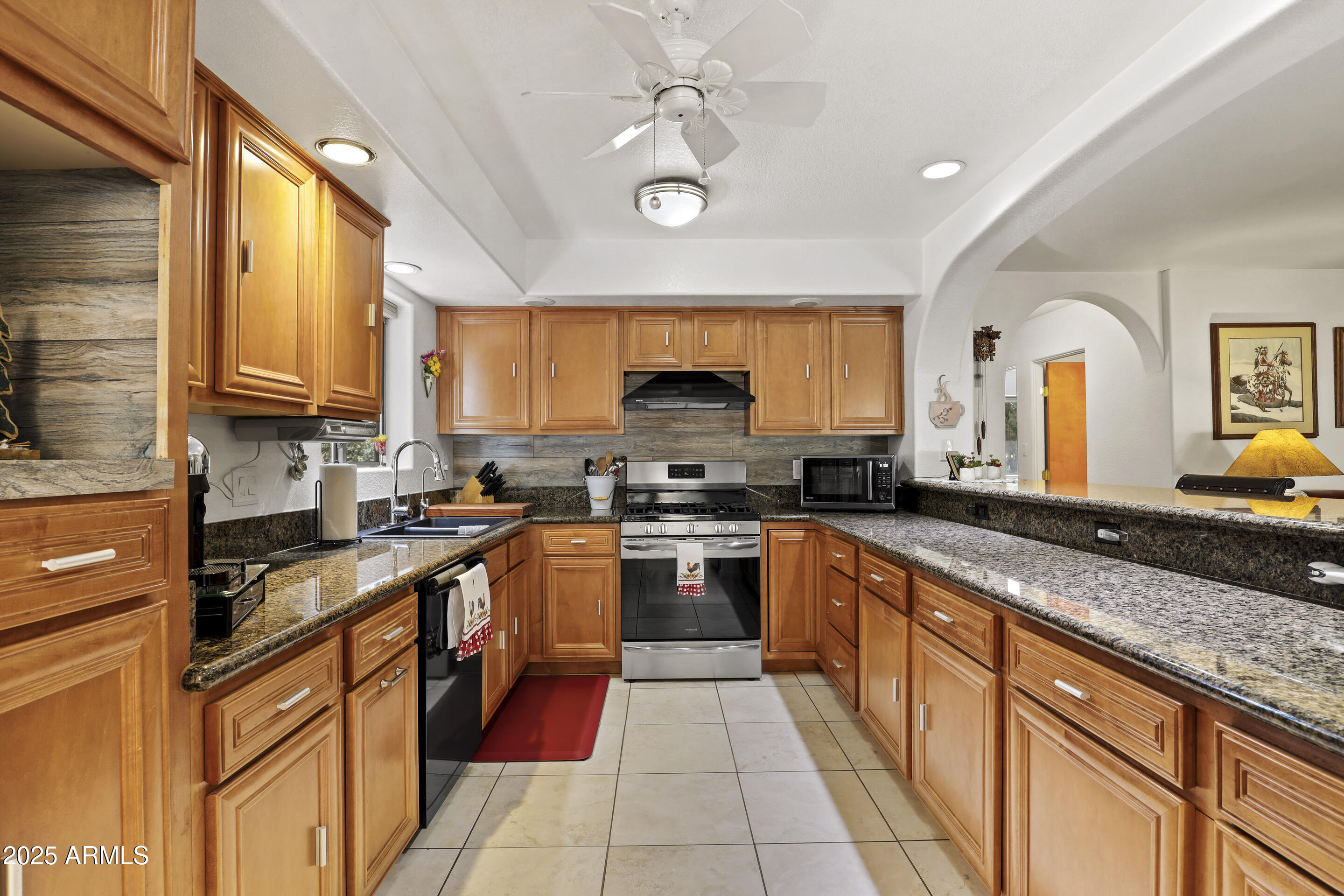 1418 North Sunset Drive Payson, AZ 85541 - Photo 12 of 48 a kitchen with stainless steel appliances granite countertop wooden cabinets a stove a sink a dining table and chairs