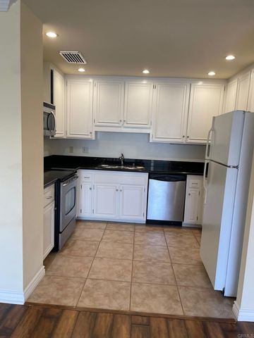 a large kitchen with stainless steel appliances granite countertop a stove a sink a refrigerator a microwave and cabinets