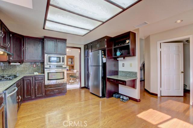 2700 Amber Circle Corona, CA 92882 - Photo 28 of 35 a kitchen with stainless steel appliances kitchen island granite countertop a refrigerator and a stove top oven