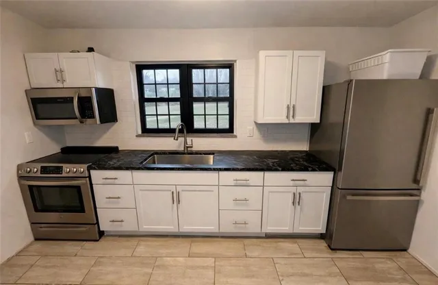 a view of water heater room with wooden floor