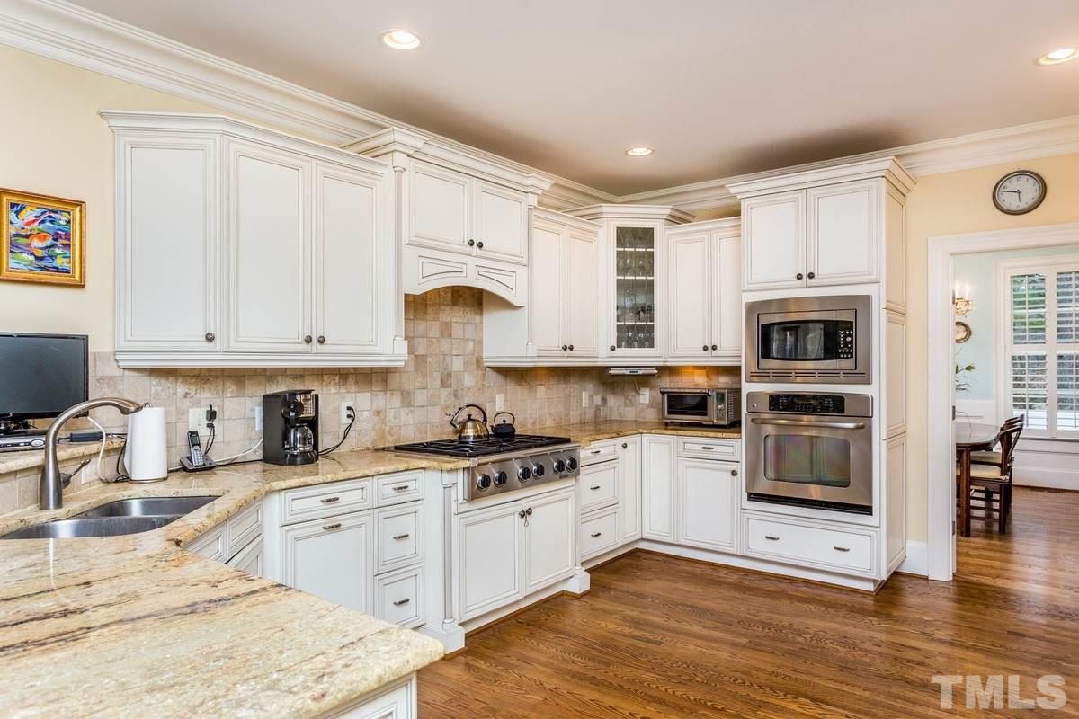 2305 Coley Forest Place Raleigh, NC 27612 - Photo 10 of 24 a kitchen with stainless steel appliances granite countertop a stove a sink and a microwave