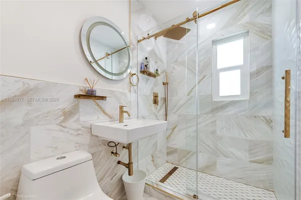 a bathroom with a sink a toilet and a mirror