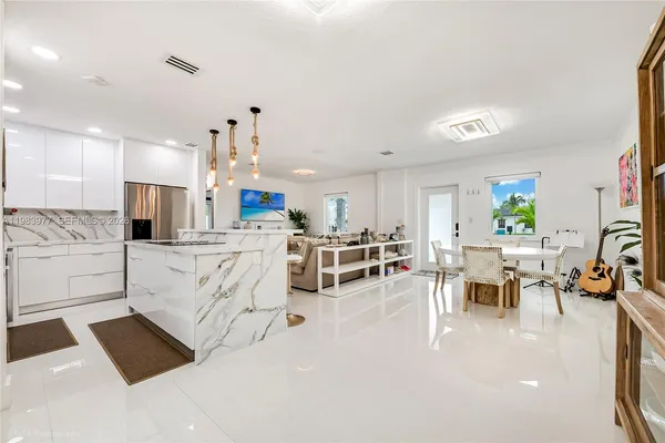 a large white kitchen with lots of counter space and windows