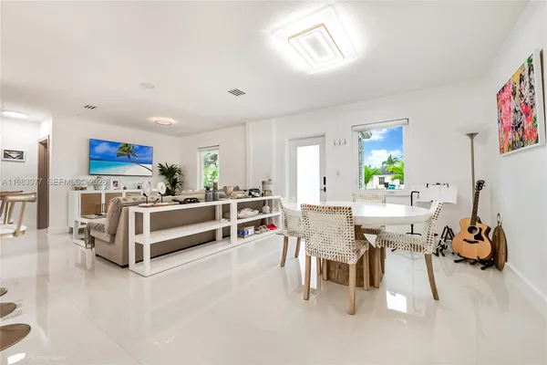 a living room with furniture a dining table and a potted plant