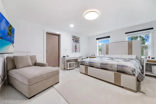 a bedroom with a bed couch and window