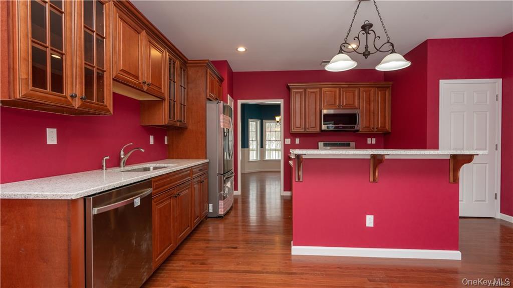 5 Harrier Ridge Drive Wallkill, NY 12589 - Photo 2 of 33 Kitchen featuring brown cabinets, a kitchen bar, appliances with stainless steel finishes, pendant lighting, and recessed lighting