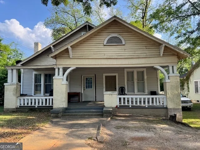 a view of a white house with large windows and a small yard