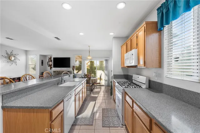 a kitchen with stainless steel appliances granite countertop a sink counter space cabinets and a couch