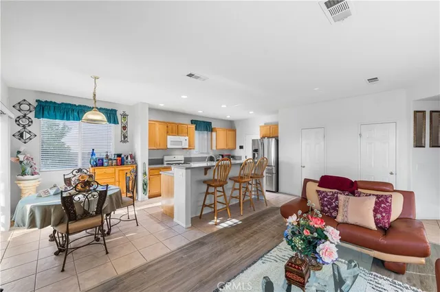 a living room with furniture dining table a rug and a flat screen tv