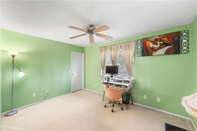 a view of a workspace with furniture and a window