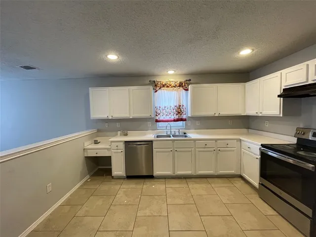 a kitchen with stainless steel appliances granite countertop a sink and stove top oven