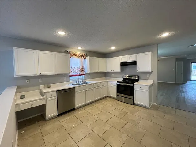 a kitchen with a sink window and cabinets