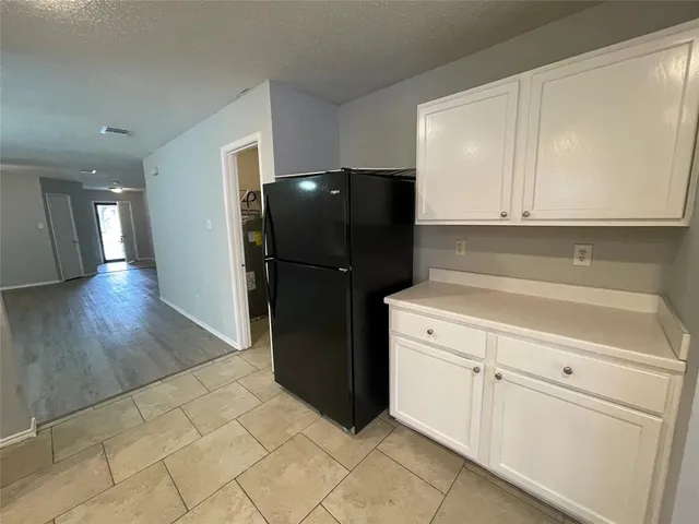 a kitchen with a refrigerator and cabinets