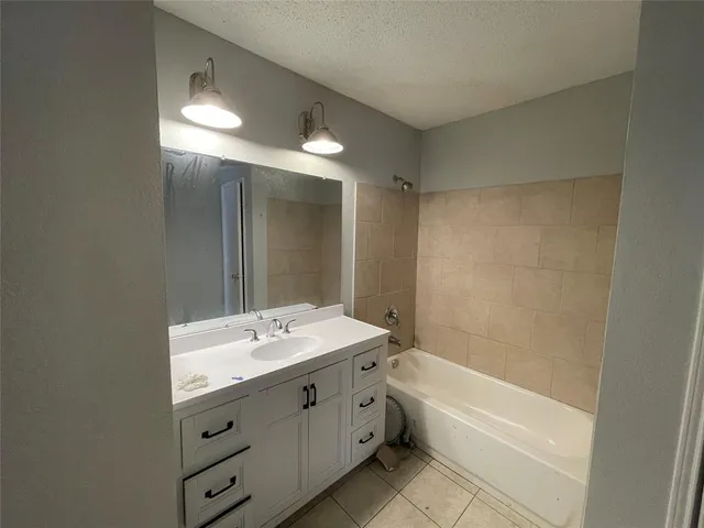a bathroom with a tub a sink shower and a mirror