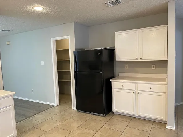 a kitchen with a refrigerator and cabinets