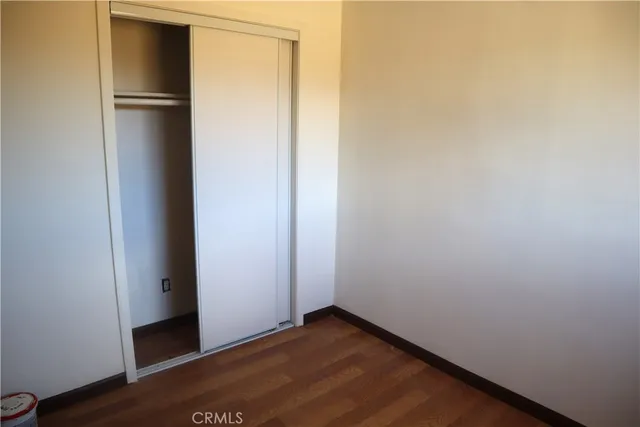 a view of an empty room with a window and a wooden floor