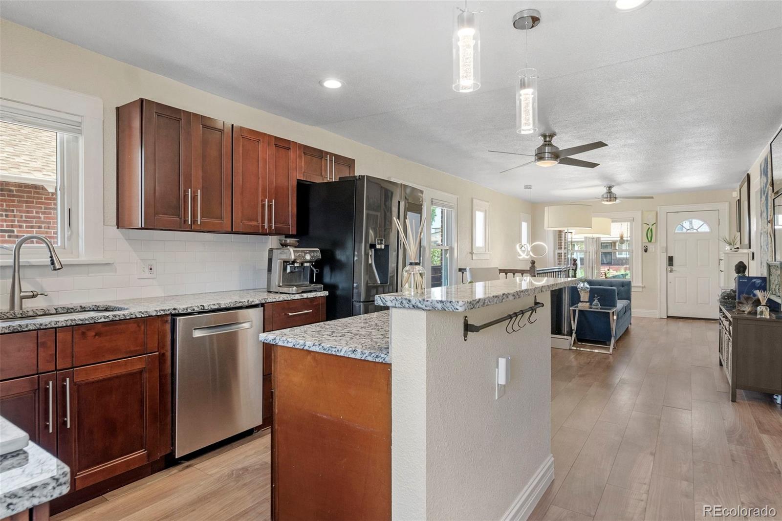 4319 Raritan Street Denver, CO 80211 - Photo 12 of 27 a kitchen with stainless steel appliances kitchen island granite countertop a sink counter space and cabinets