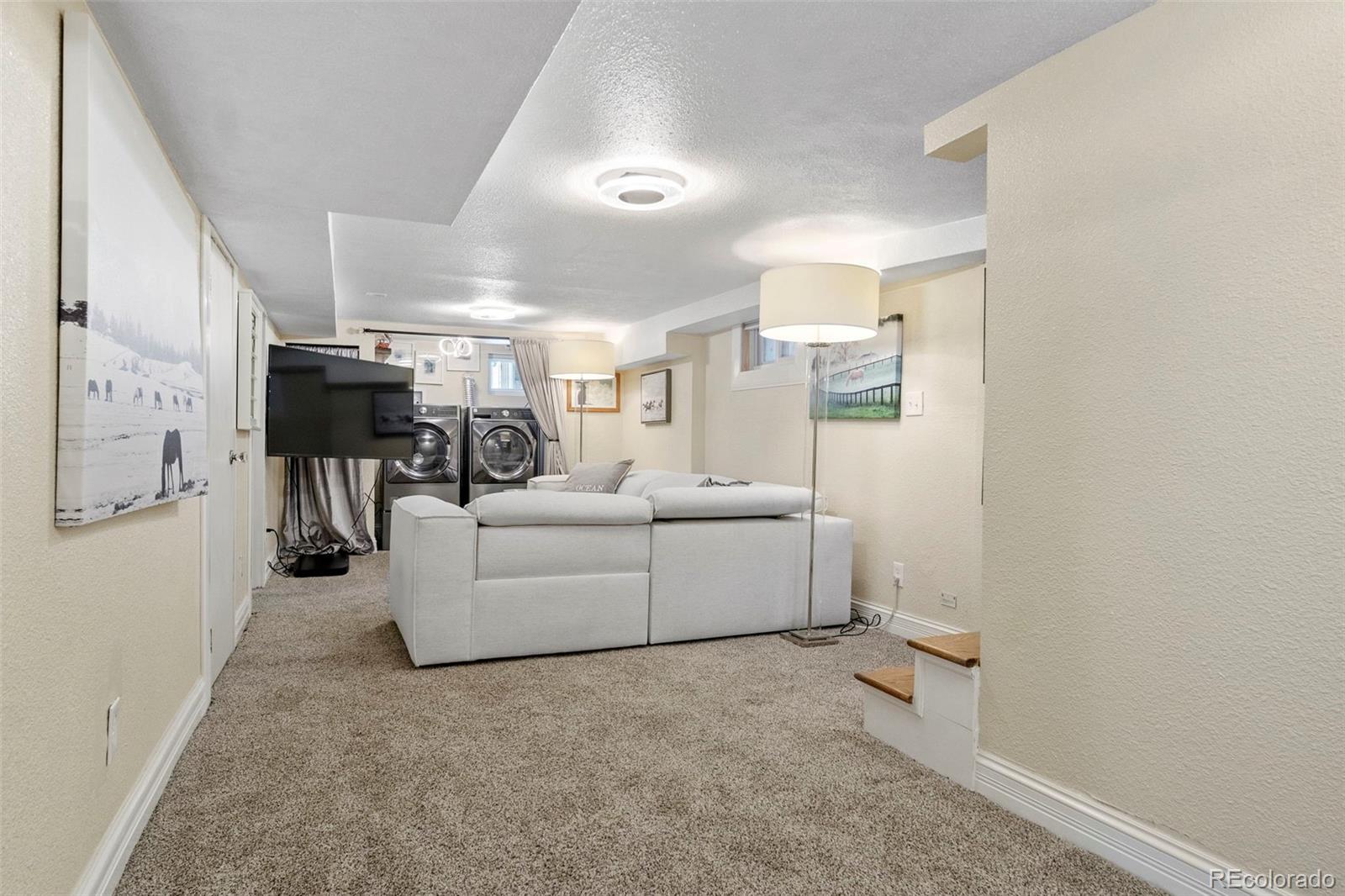 4319 Raritan Street Denver, CO 80211 - Photo 15 of 27 a living room with furniture and a flat screen tv