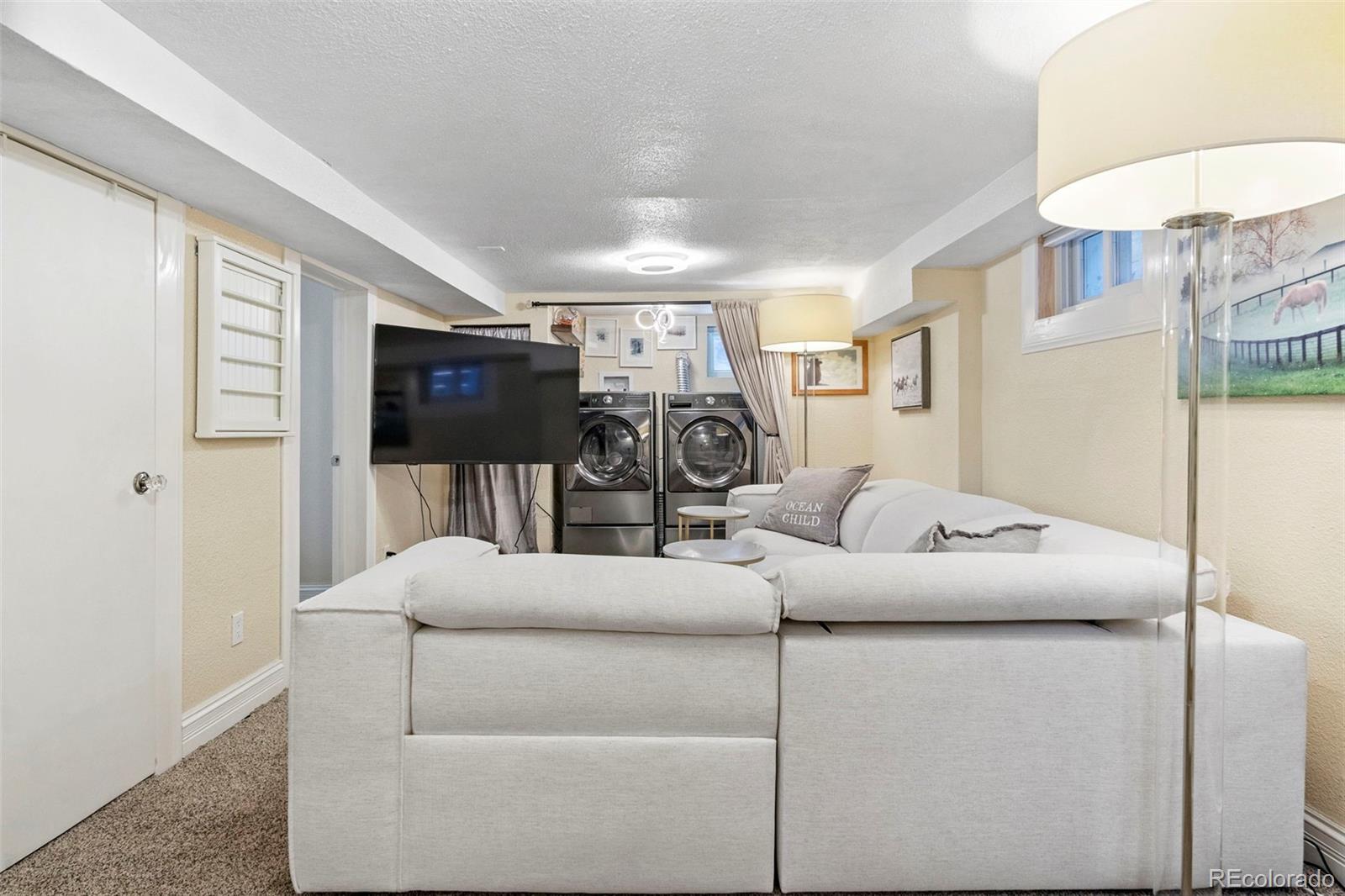 4319 Raritan Street Denver, CO 80211 - Photo 16 of 27 a living room with furniture and a flat screen tv