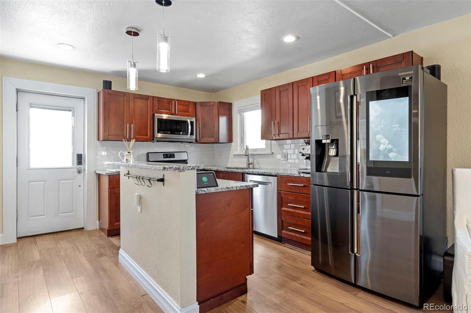4319 Raritan Street Denver, CO 80211 - Photo 10 of 27 a kitchen with stainless steel appliances granite countertop a refrigerator a stove top oven a sink and dishwasher with wooden floor