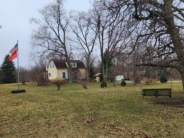 a backyard of a house with barbeque oven table and chairs