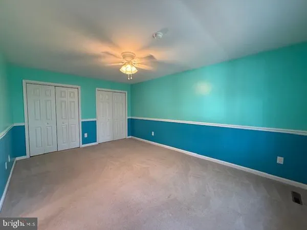 a view of a room with a ceiling fan and a window