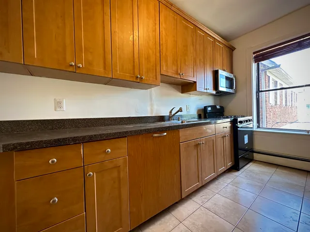 a kitchen with stainless steel appliances granite countertop a sink stove and cabinets